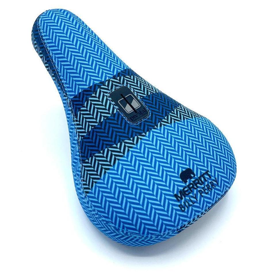 The Merritt Billy Perry Pivotal Seat features a blue chevron pattern, durable canvas cover, rectangular black mounting slot, and "MERRITT BMX PERA" branding on the front.