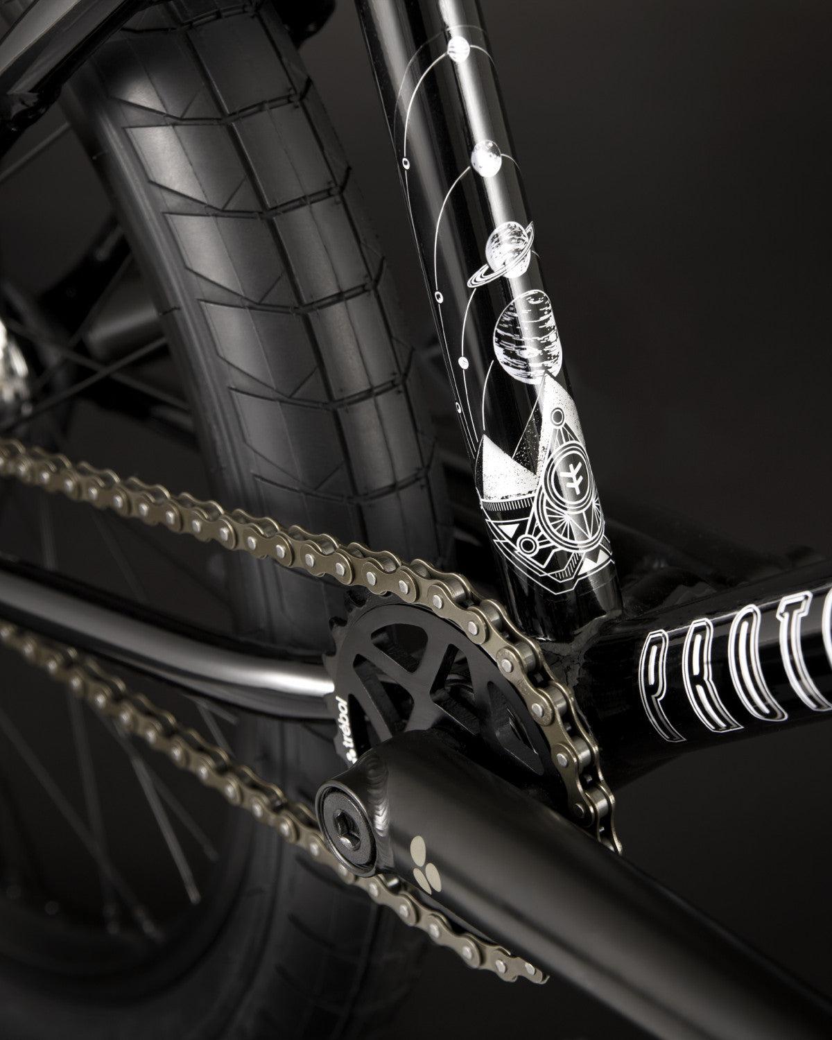 Close-up of the Fly Bikes Proton FC 20 Inch Bike's black BMX chain and CrMo frame, showcasing a detailed astronaut and space-themed design.