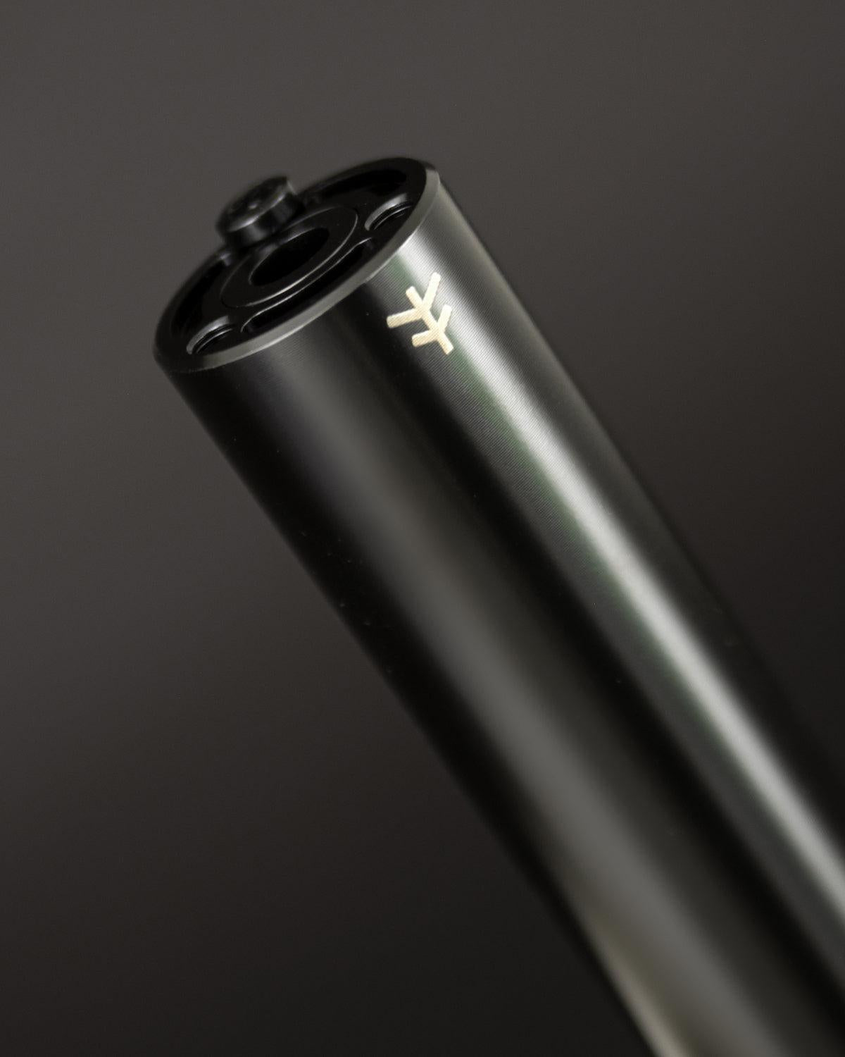 Close-up of the sleek black Fly Bikes Acero ST Peg, expertly CNC machined from 4140 Cr-Mo, featuring a subtle logo on its surface, against a dark background.