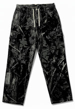 Monticule Ocean Park Cargo Pants in dark camo with white waist drawstring and side pockets, crafted with Dura-flex technology for durability and comfort, shown laid flat on a white background.