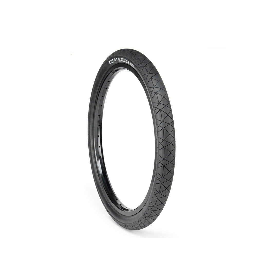 The ECLAT Mugen Flatland Tyre, known for its high performance on flatland terrains, showcases a textured tread pattern and is displayed upright against a white background.