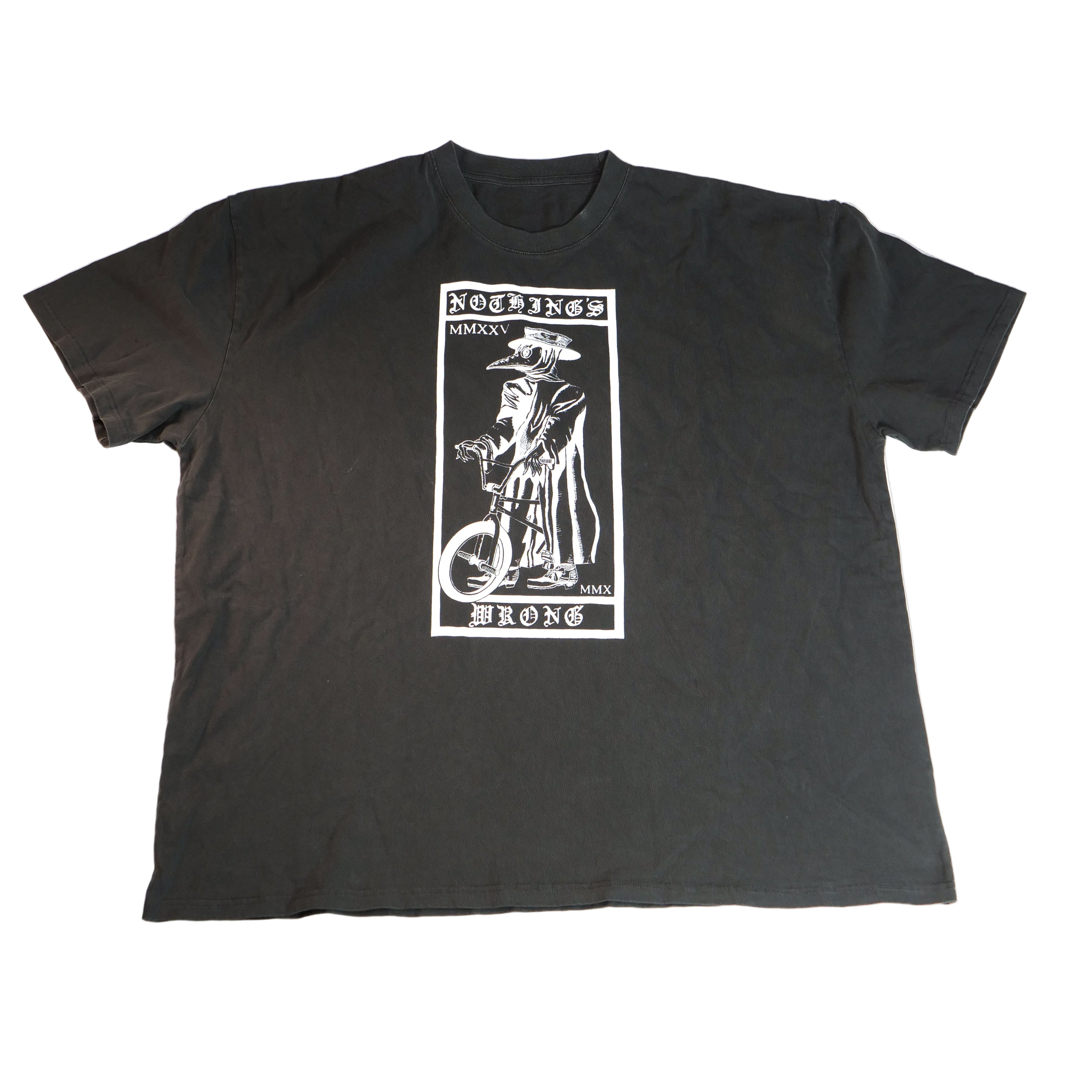 The Nothing’s Wrong Plague T-Shirt is a black BMX tee with a white cloaked unicyclist graphic, "NOTHING'S WRONG" and "MMXXI" text, and is hand-printed for unique style.