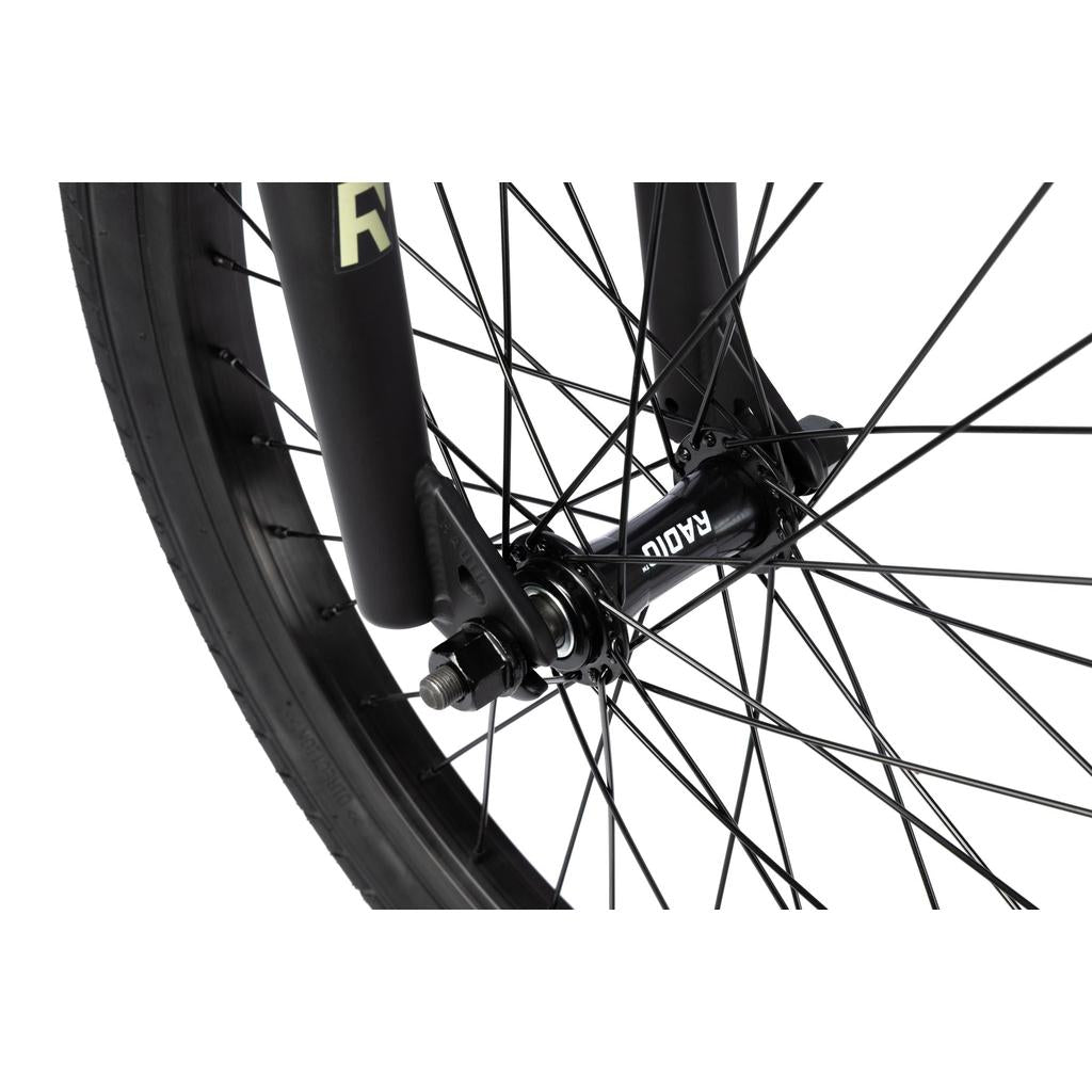 Close-up of the front wheel on a black Radio Evol XL 20 Inch Bike, showing its spokes, axle, fork, and a “RADIAL” labeled hub against a white background.