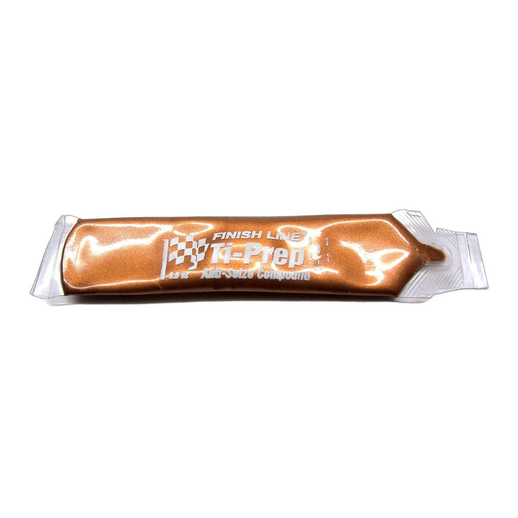 A sealed packet of Odyssey Anti Siese Grease with a transparent side reveals the bronze-colored paste inside, designed to withstand extreme pressures and effectively prevent metal-to-metal contact.