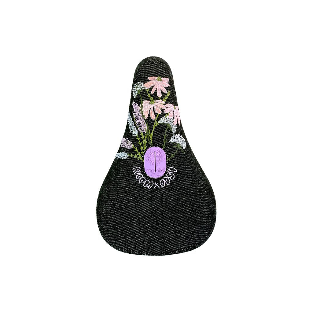 Odyssey Bloom Pivotal Seat with embroidered flowers and skull design, isolated on a white background.