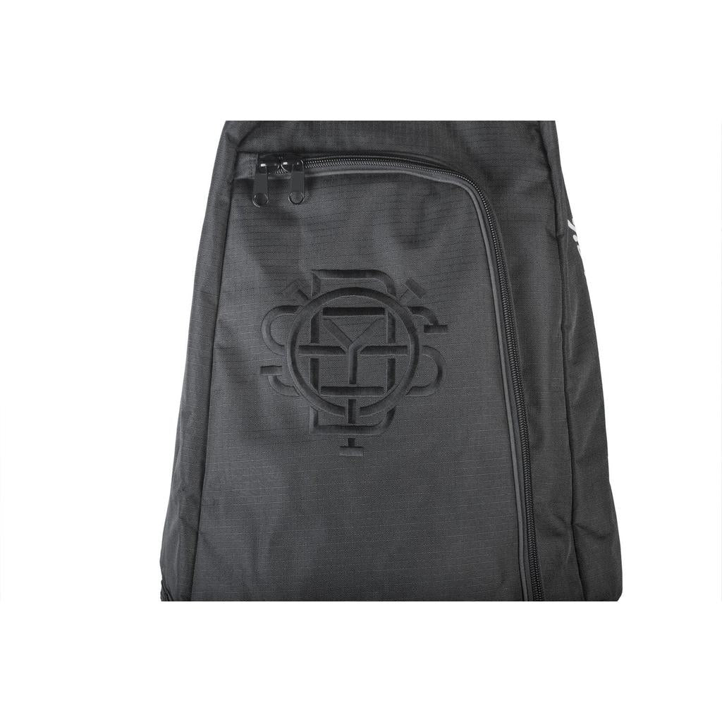 The Odyssey Monogram Bike Bag is a black travel bag featuring a prominent embossed circular logo on the front zipper pocket, ideal for your next adventure.