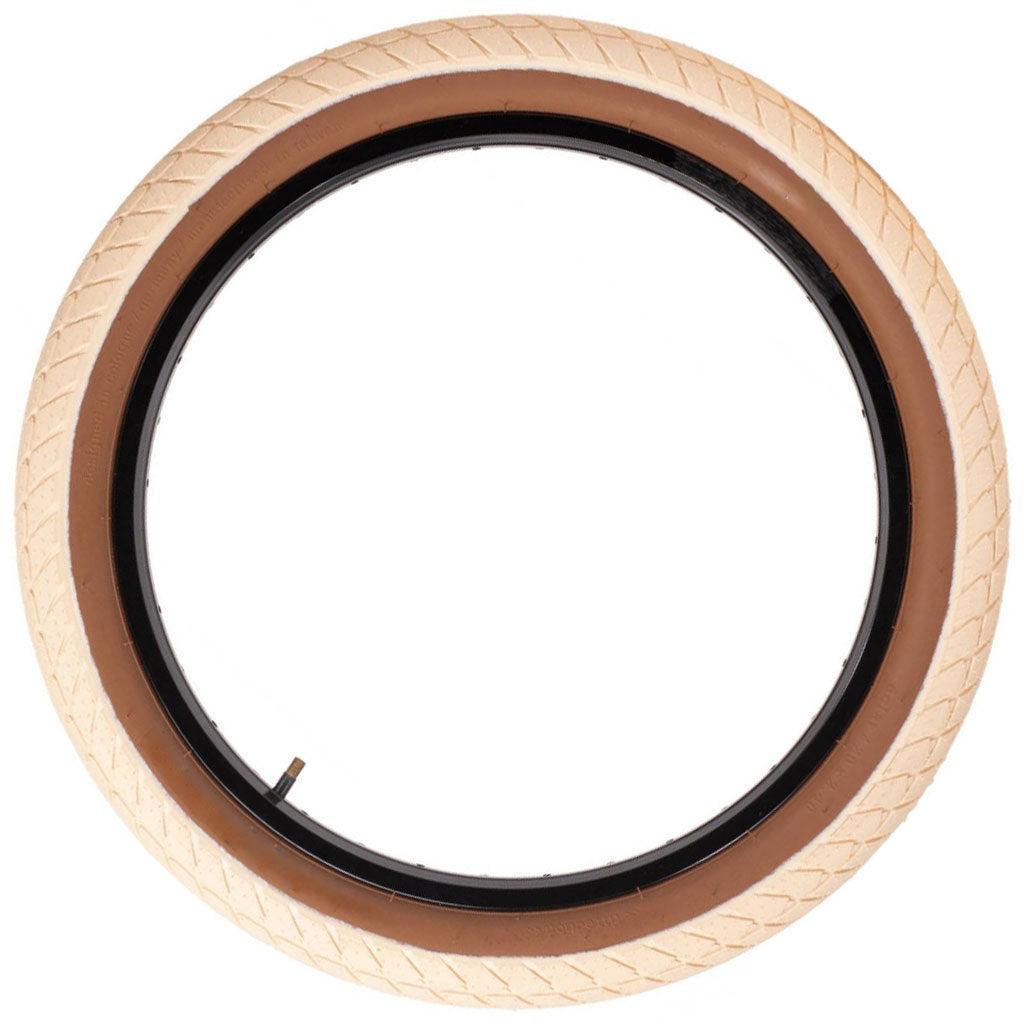 A top-down view of the beige Eclat Optima Tyre displays its all-terrain tread pattern and black inner lining.