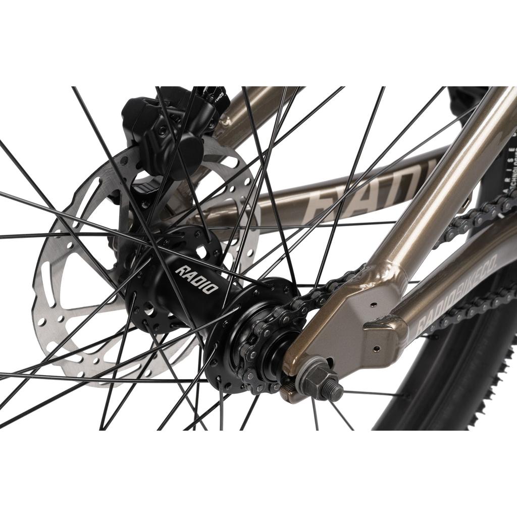 Close-up of the Radio Griffin 24 Inch Dirt Jumper Bike’s rear wheel, featuring a disc brake, RADIO-labeled hub, spokes, and part of its aluminum frame—perfect for pumptrack or dirt jump riding.