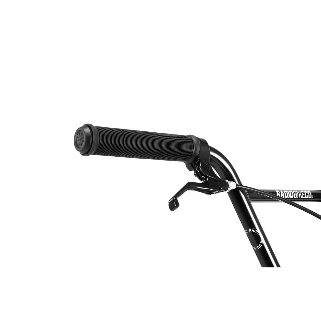 Close-up of a black handlebar with rubber grip and brake lever on the Radio Dice 18 Inch Bike, set against a white background. The frame shows part of the word "RAD.