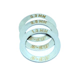 Four metal washers from the PROFILE AC2 HUB SHIM KIT, featuring engraved thickness measurements of 0.3 mm, 0.5 mm, 1.0 mm, and AC-8, are arranged in a slightly overlapping manner.