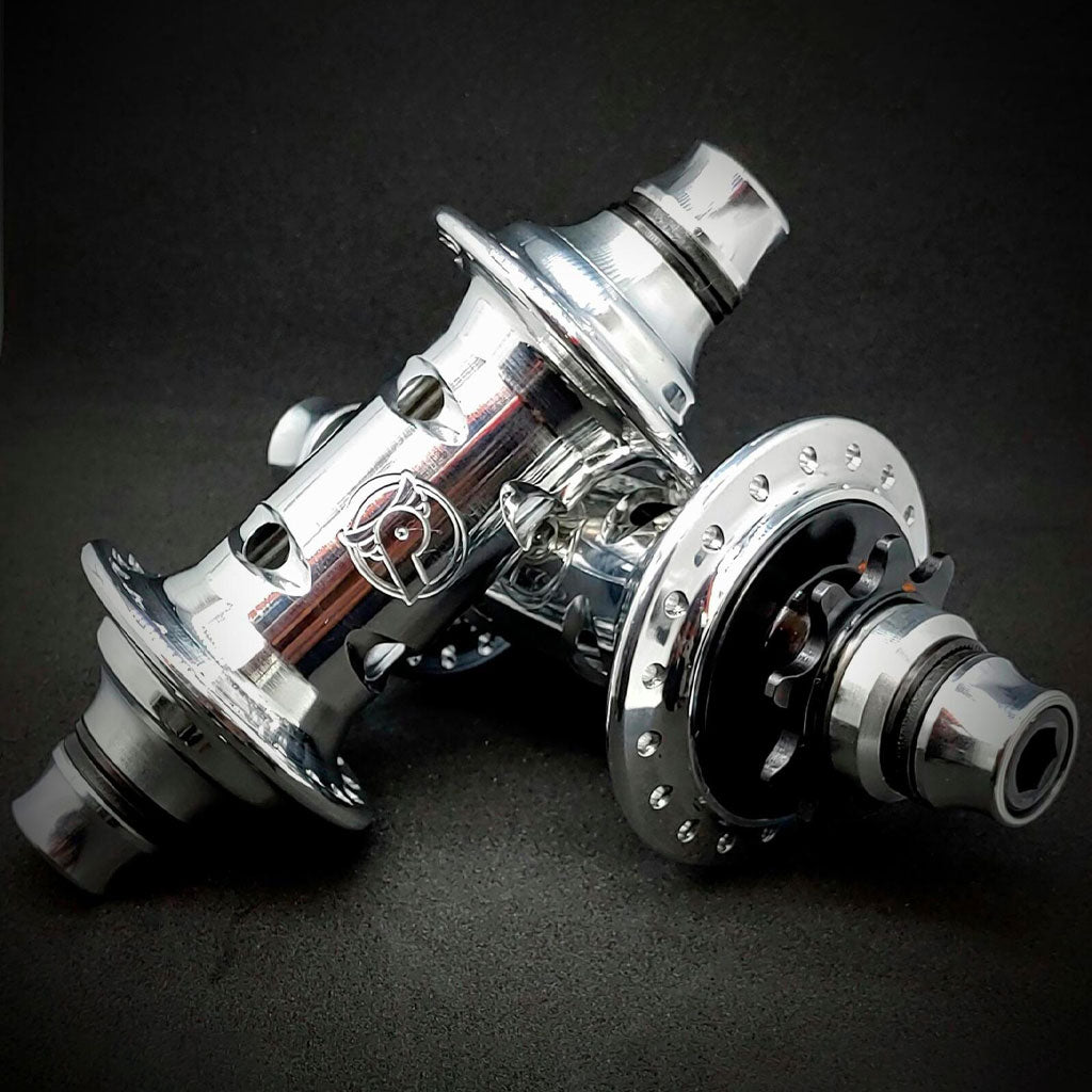 The PROFILE Limited Edition Cat's Eye Hub Set features two polished silver hubs with multiple spoke holes and detailed engravings, displayed against a dark background.