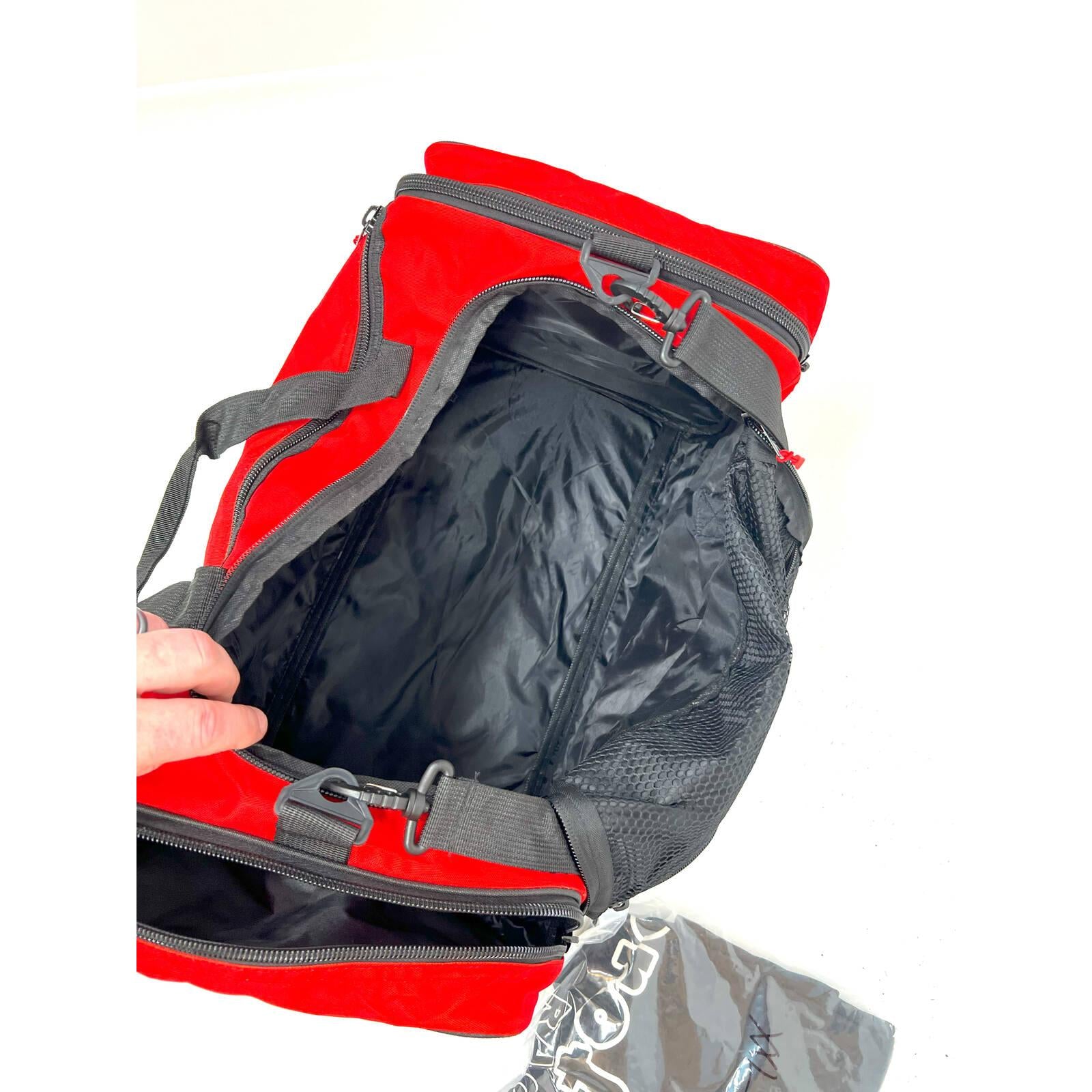 A Profile Racing Custom Team Gear Bag, made from durable 600D polyester, sits with open compartments. A hand reaches to open the bag, while nearby a pack of small plastic bags can be seen.