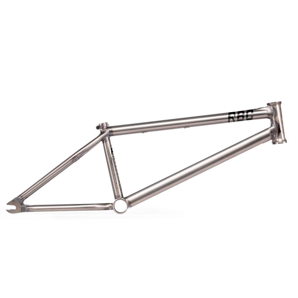 The Radio Nemesis Frame is a bare metal BMX frame with a minimalist design, welded joints, and "RBF" marked near the front.