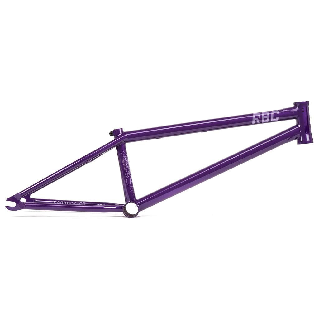 The Radio Saxon Frame is a purple BMX frame with white "RBC" lettering, featuring technical skatepark geometry and displayed side-on against a white background.