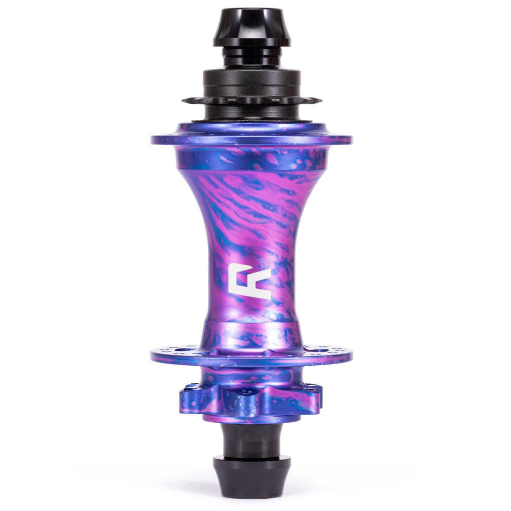 The Radio Sonar Rear MTB Hub showcases a vibrant mix of purple and blue with pink swirls, black spoke holes, and a central logo.