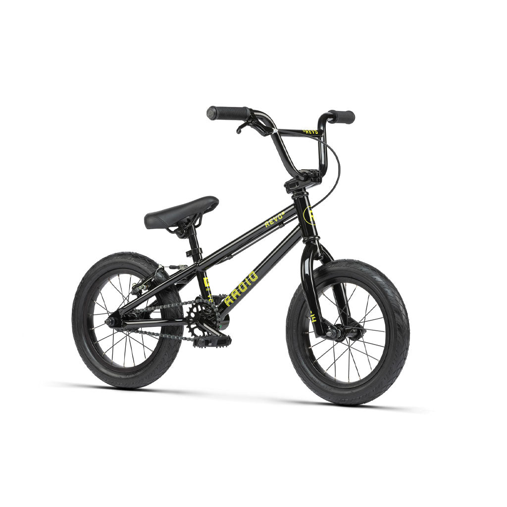 The Radio Revo 14 Inch bike is a black BMX bike with yellow accents, featuring a sturdy frame, thick tires, and a padded seat - making it an ideal first bike for young riders.