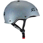 A sparkly silver S-One Helmet Mini Lifer Silver Gloss Glitter with black straps and a red buckle, featuring the "S-ONE" logo on the adjustable chin strap and the "S1" logo on the side. This multi-impact helmet is equipped with EPS Fusion Foam for superior protection.