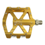 The SD CNC V2 Junior/Expert Pedals feature a gold flat alloy body with cutout design, precision sealed bearings, metal pins for grip, and a central "SD" logo.