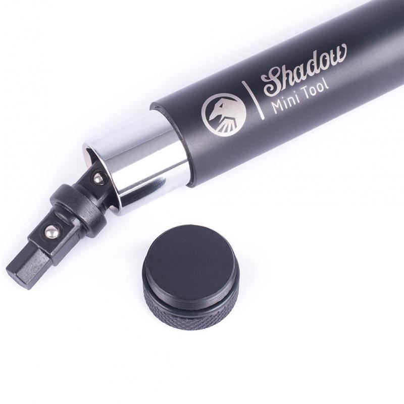 A Shadow Mini Tool, featuring a hexagonal tip and a detachable circular cap, is displayed in black with silver accents.