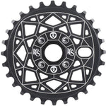 The Shadow VVS Sprocket is a black chainring made from 7075 alloy, adorned with white geometric patterns and symbols.