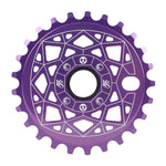 The Shadow VVS Sprocket is a purple bicycle sprocket with geometric cutouts and a sleek white line design. It's crafted from durable 7075 alloy, featuring a central circular hole surrounded by intricate details, blending form and function beautifully.