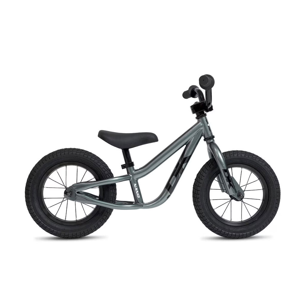 The DK Nano Balance Bike features a gray frame with black handlebars, saddle, and thick black tires. Shown in profile against a white background, it’s an ideal kids' balance bike for beginners.