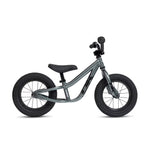 The DK Nano Balance Bike features a gray frame with black handlebars, saddle, and thick black tires. Shown in profile against a white background, it’s an ideal kids' balance bike for beginners.