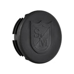 The S&M End Cap Slide Pipe Rail is a black circular cap with grooved edges, featuring an embossed shield logo with "S & M" letters, perfect as a replacement end cap or rail accessory.