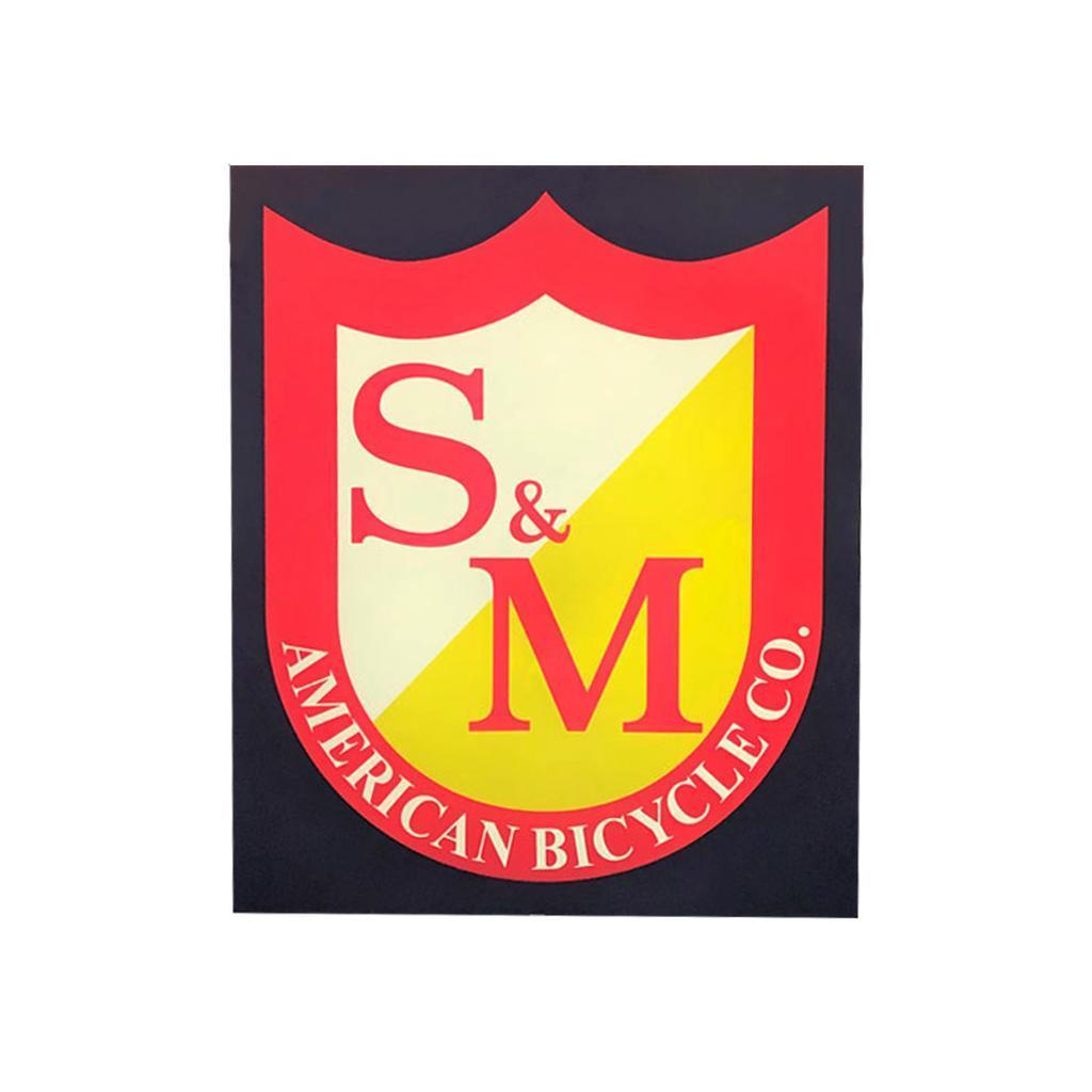 Display your love for S&M AMERICAN BICYCLE CO. with the S&M Shield Banner, featuring a bold red and yellow shield logo with “S&M” lettering and “AMERICAN BICYCLE CO.” around the bottom edge.