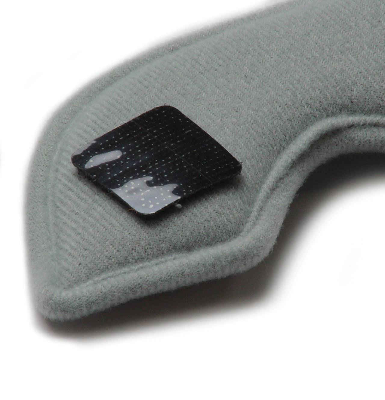 Close-up image of a grey fabric armrest or cushion with a black rectangular patch attached to it, featuring the washable sweat absorbing S-One Helmet Wide Terry Cloth Liner for added comfort.