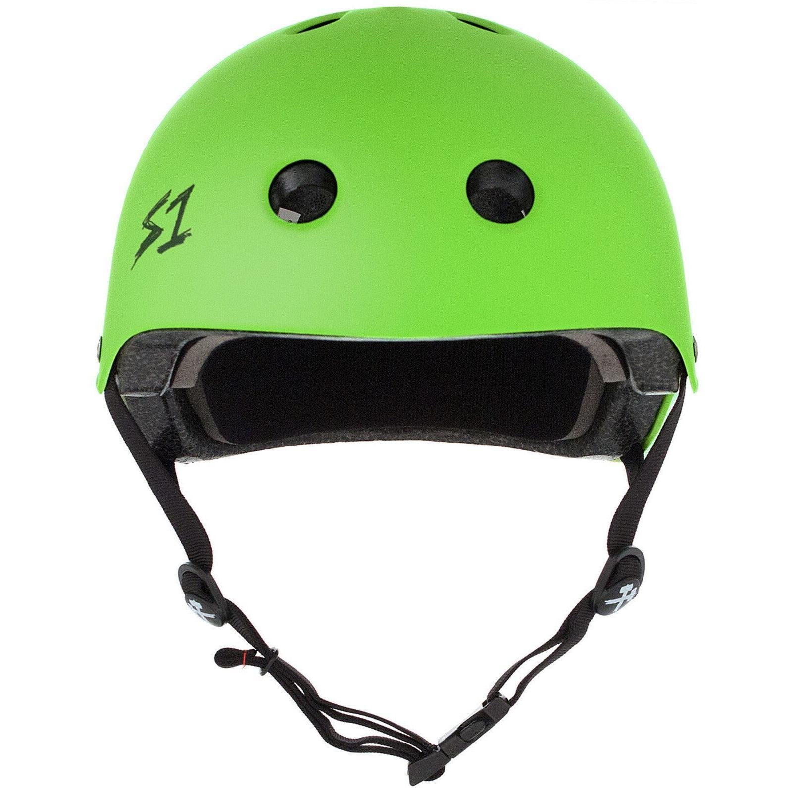 The S-One Lifer Helmet in Bright Green Matte features black vents, a black "S1" logo on the left, and an adjustable black chin strap, providing certified multi-impact protection for skating.