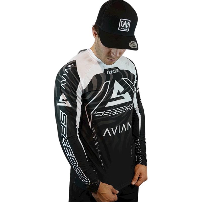A man in the Speedco / Avian Race Jersey with an aerodynamic fit and a black cap, both displaying the AVIAN and SPEEDCO logos, stands with hands in front—embodying focused race-day apparel style.