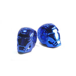 Superhero Valve Caps (Pair) are shiny blue metallic, helmet-shaped accessories designed to fit Schrader valves. Resembling stylized Iron Man masks, they add a playful touch to your car. Shown on a white background.