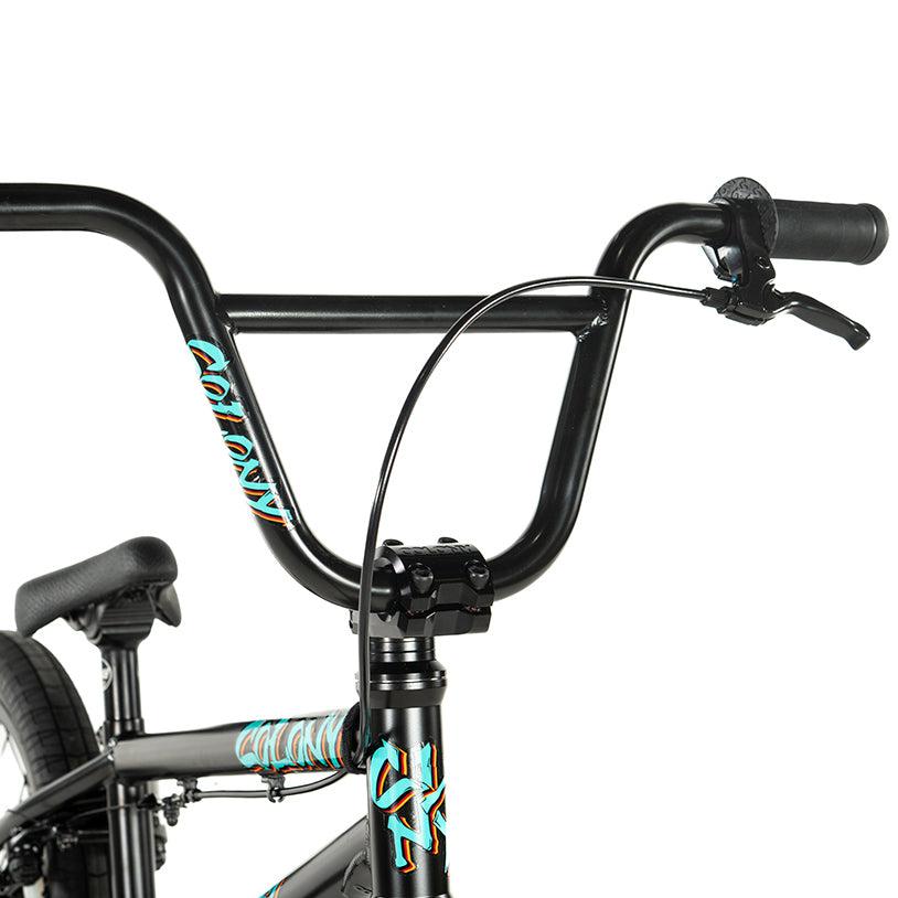 Close-up of a black BMX handlebar with a brake lever and colorful decals, highlighting the sleek design of the Colony Sweet Tooth Pro Elite 16 Inch Bike.