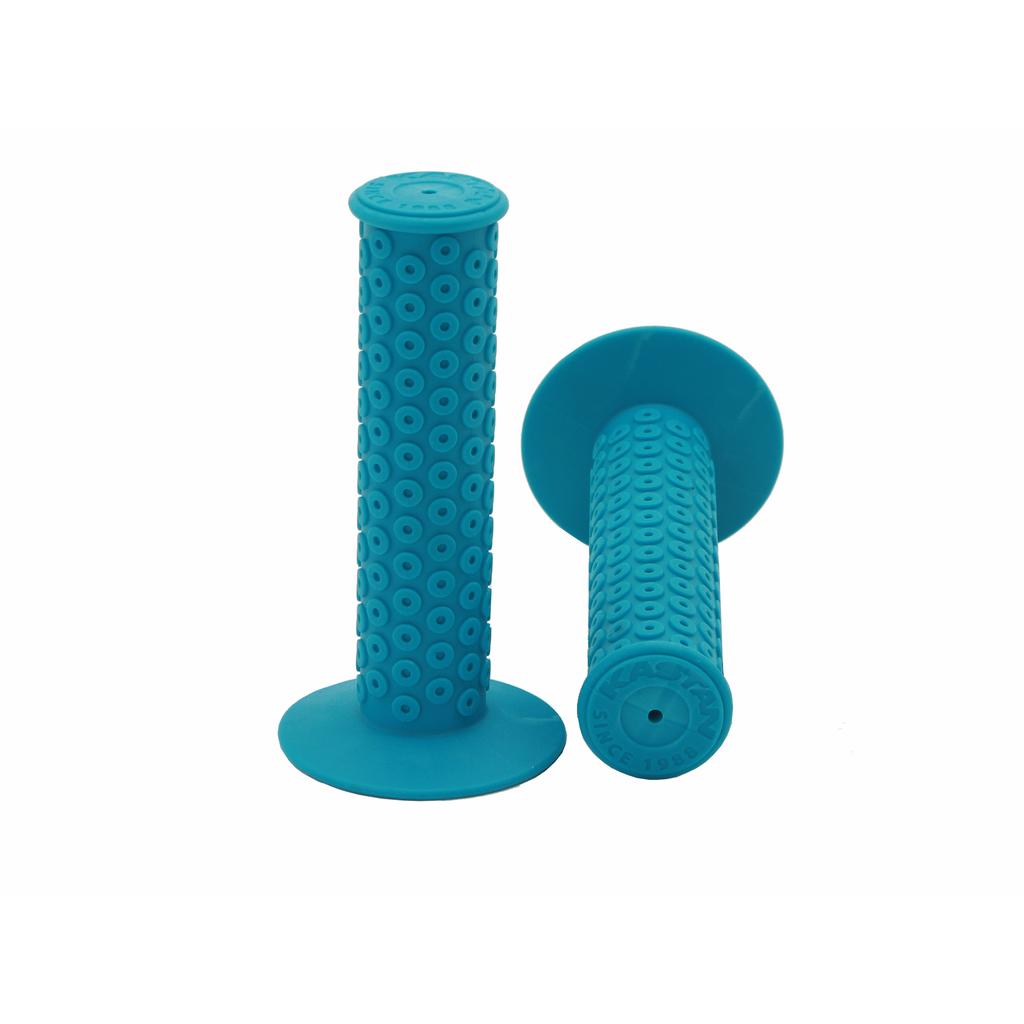 Two blue Kastan Grips with circular textured patterns and flared ends, ideal for RL II builds or era-correct rubber restorations, shown upright and on their side against a white background.