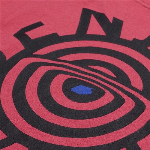 A close-up of the TLD 25.1 Enjoy LS Shirt's red long sleeve reveals a black concentric circle pattern, highlighted by a small blue oval shape in the center.
