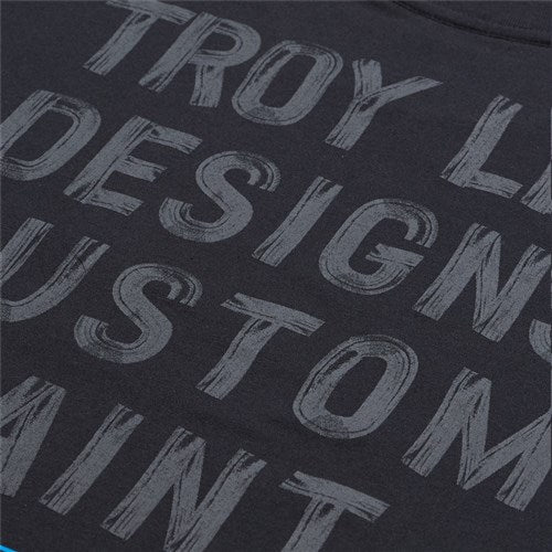 Close-up of the TLD 25.1 Paint Shop SS T-Shirt, a black tee with bold gray "Troy Lee Designs Custom Paint" text, ideal for relaxing with a sleek and edgy vibe.