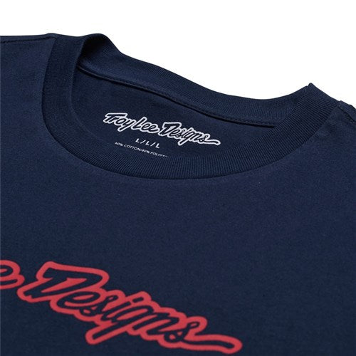 The TLD 25.1 Signature SS T-Shirt is a navy blue tee with "Troy Lee Designs" in red cursive on the inside collar and chest, highlighting an iconic brand.