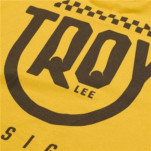 The TLD 25.1 Smiley SS T-Shirt is a yellow tee featuring the black "TROY LEE" text and a checkered pattern, perfect for adding some brightness to your life.