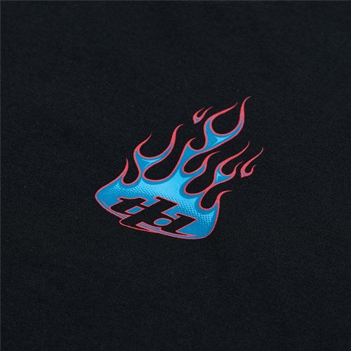The TLD 25.1 Torched SS T-Shirt showcases a small red and blue flame graphic with "tbj" text on a black background, capturing the dynamic style of a red hot tee.