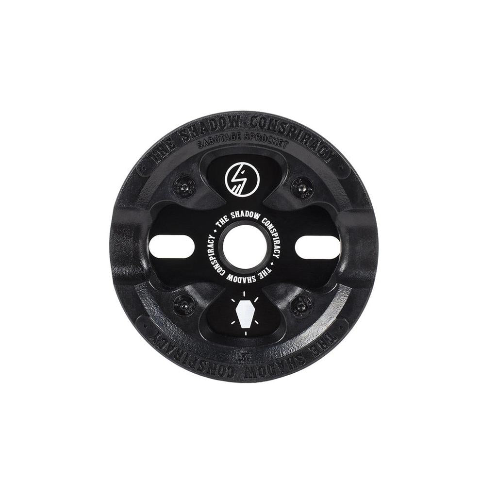 A black Shadow Sabotage Sprocket with a protective guard, logo, and center text is shown on a white background. It’s compatible with the Shadow Conspiracy Supreme chain.