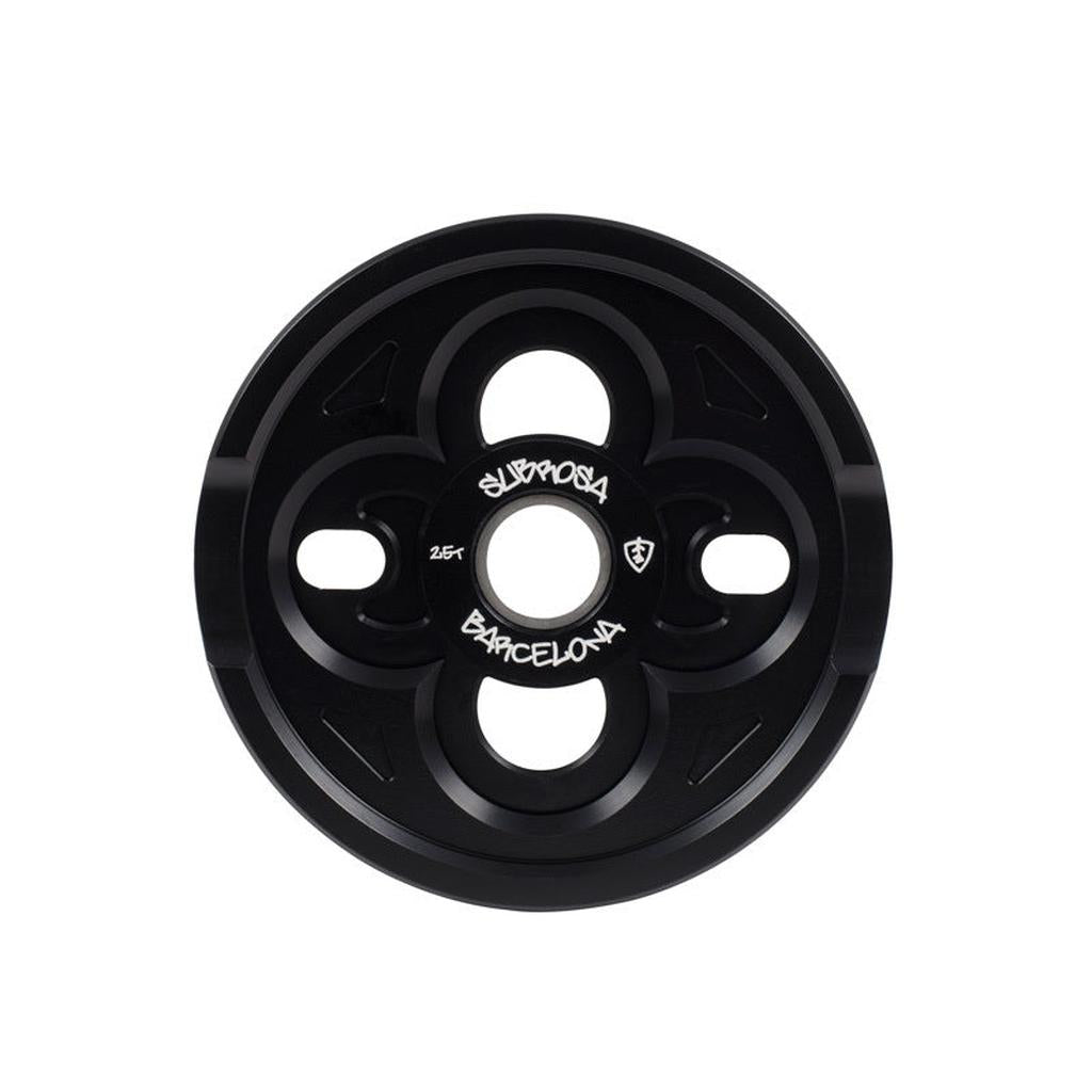 The Subrosa Barcelona Sprocket is black, crafted from tough 7075-T6 alloy, with four keyhole-shaped cutouts and "Subrosa Barcelona" in white at the center.