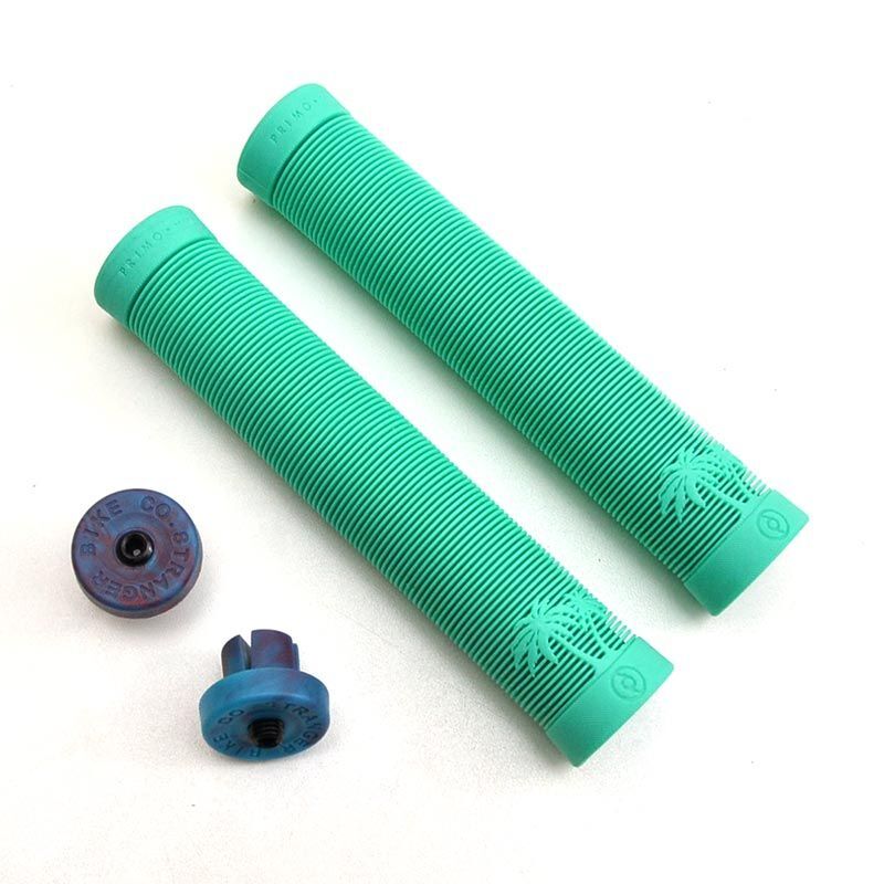 Two turquoise Primo Cali Grips with ribbed palm tree designs are displayed alongside two blue plastic bar end plugs on a white background.