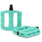 Two turquoise Rant Trill Plastic Pedals with textured nylon composite bodies, chromoly axles, and rectangular cutouts—one stands upright while the other lies flat.