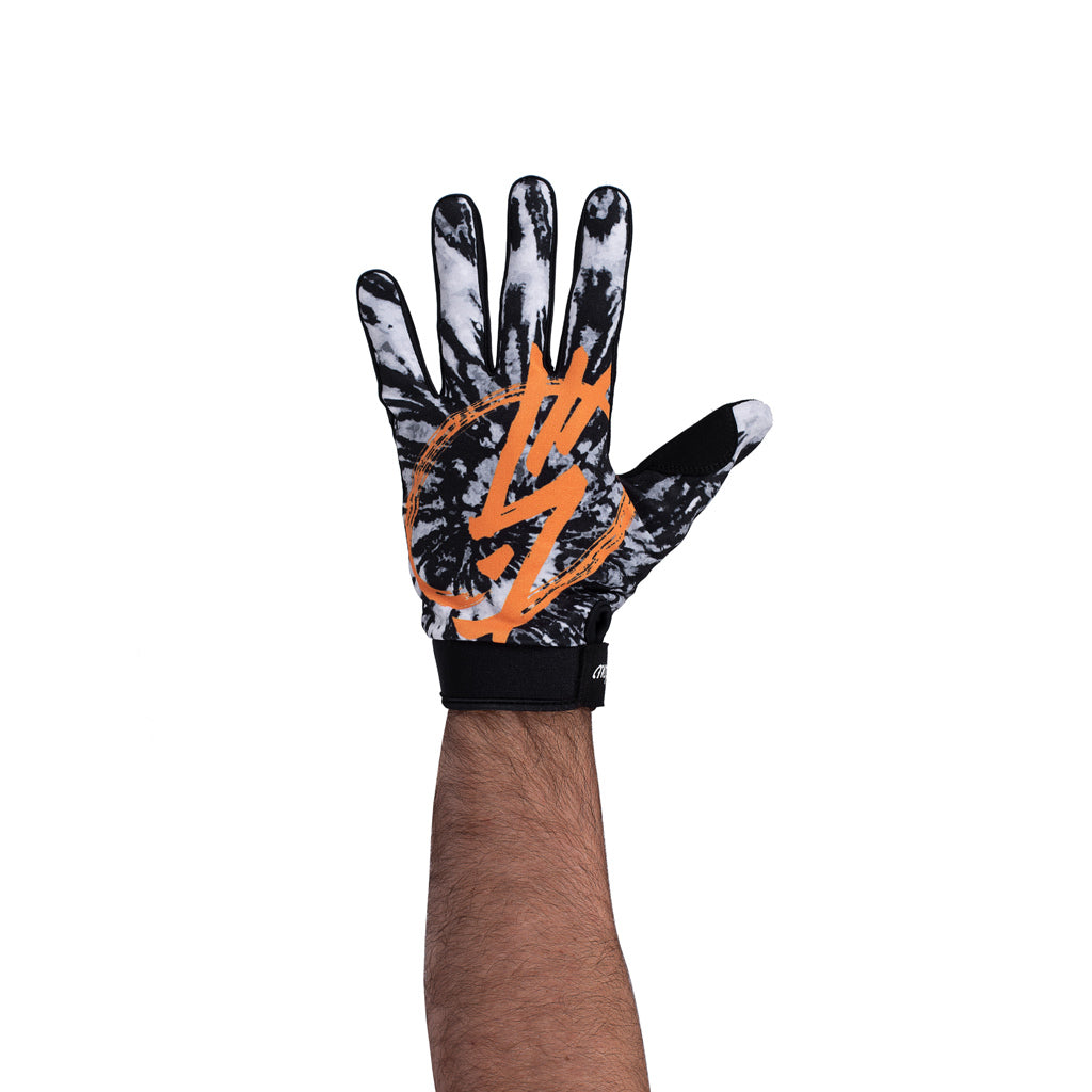 A man's hand wearing Shadow Conspire Gloves with an orange and black design.