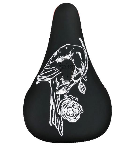 The Subrosa x Shadow Rose Crow Pivotal Seat features a black base with a white embroidered bird on a floral branch, blending unique design with Shadow and Subrosa collaboration for both style and Pivotal system compatibility.