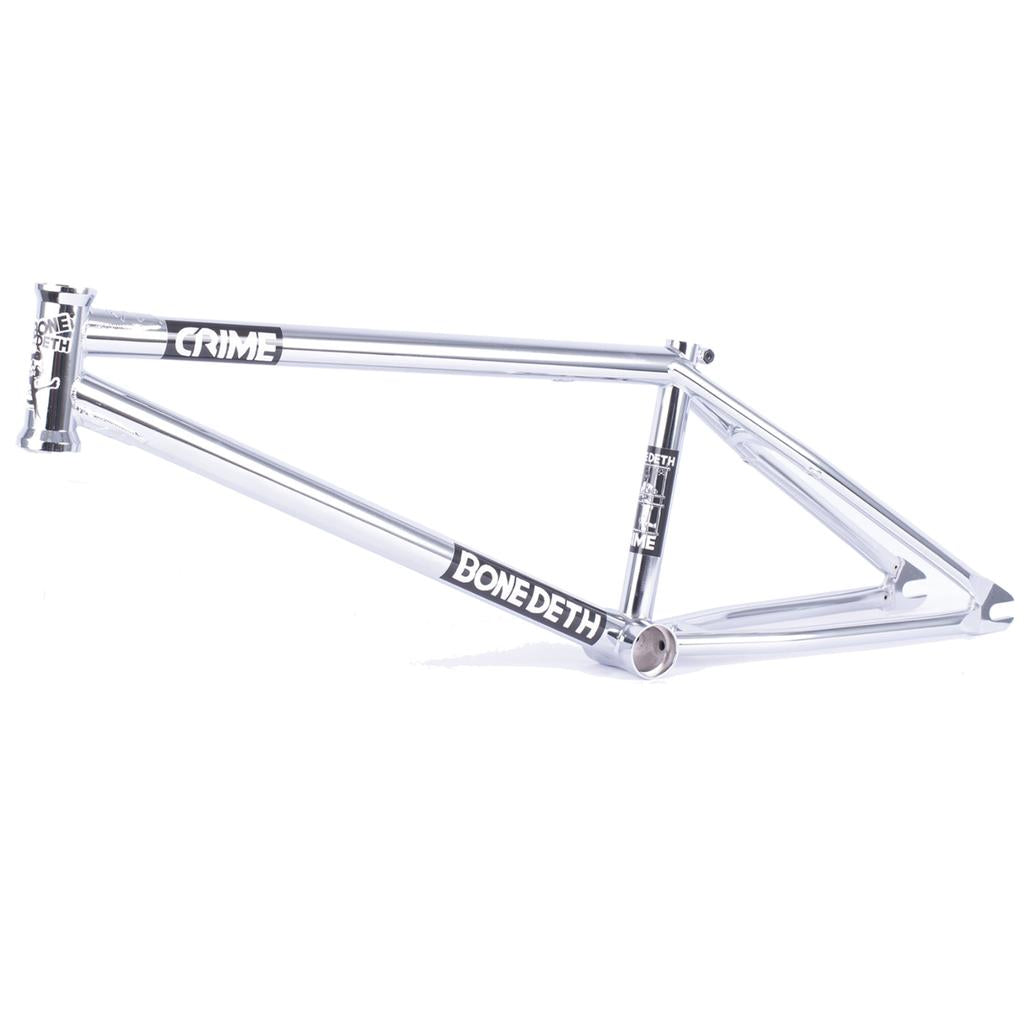 The Bone Deth Crime Frame is a silver BMX bike frame adorned with "Bone Deth" and "Crime" logos on the tubing, presenting one of the coolest brands, with its chrome finish gleaming against a pristine white background.
