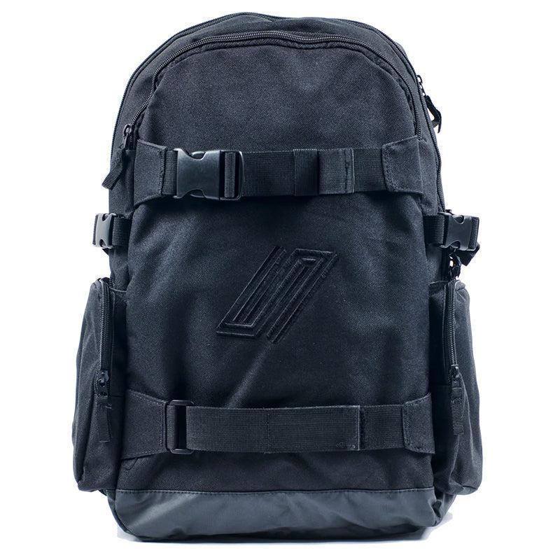 The United Dayward Backpack showcases a black design with two front buckles, side pockets, a subtle geometric logo, and skateboard carry straps, all set against a white background.
