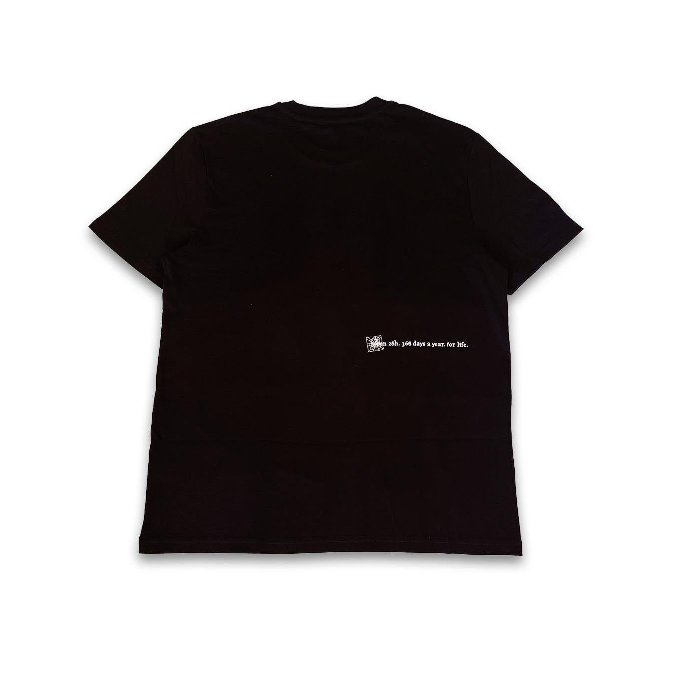 The V1da Web T-shirt in black is shown laid flat, back view, with a small white screenprint and "oh, 100 days since her life." text on the lower right. Made from 100% cotton for comfort.