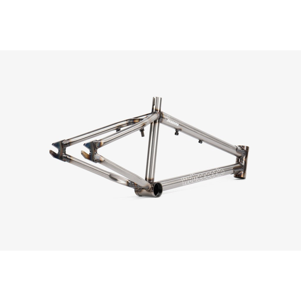 A Wethepeople 4 Seasons Frame, in a striking silver finish, lies elegantly on its side against a pristine white background.